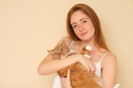 Photo for Red-haired girl with a ginger cat. - Royalty Free Image