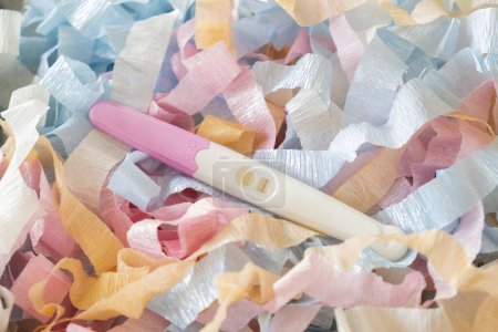 Foto de Prueba de embarazo positiva en trozos de papel de color. - Imagen libre de derechos