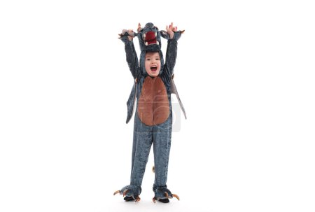 Téléchargez les photos : Petit garçon en costume de dinosaure sur fond blanc isolé. - en image libre de droit