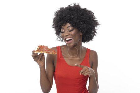 Photo for Fashionable young African American woman with a slice of her favorite pizza. - Royalty Free Image