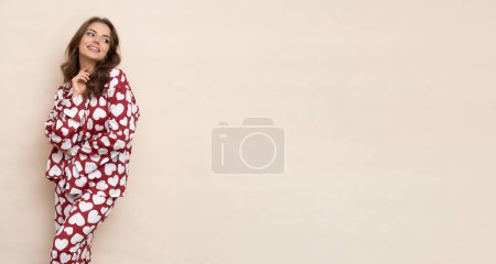 Photo for Well-slept and relaxed brunette in heart-print pajamas. - Royalty Free Image