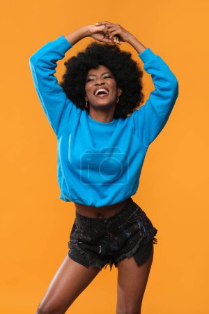 Photo for Happy African American woman in blue sweatshirt. - Royalty Free Image