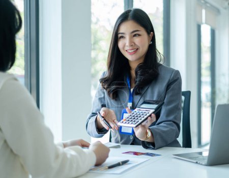 Asiatische Geschäftskunden-Service-Vertreter arbeiten und lächeln dienen Verkauf von Kreditkarten an Kunden. Versicherungswahl im Amt.