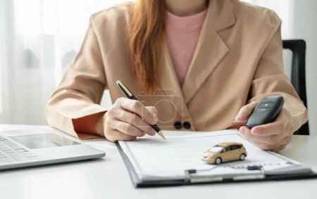 Autohändlerin unterschreibt Kfz-Versicherungsdokument oder Leasingpapier. Autokredit und Versicherungskonzept.
