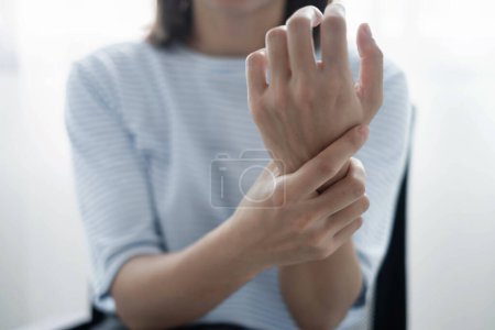 Frau Hand mit Schmerzen im Handgelenk Taubheitsgefühle und Schmerzen in der Handinnenfläche hat Schmerzen und Kribbeln in den Nervenenden Dies ist eine Nebenwirkung des langen Sitzens und Arbeitens am Laptop im Büro.