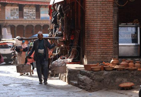 Téléchargez les photos : Katmandou, Népal - 20 novembre 2023 : un ouvrier place le potier. potier est sous séchage au soleil pocessing dans le Talako Tole ou ce que l'on appelle la poterie carré. - en image libre de droit