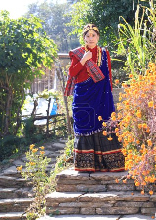 Photo for A villager girl dressing in Gurung traditional dressing walk down the staircase and look at camera - Royalty Free Image
