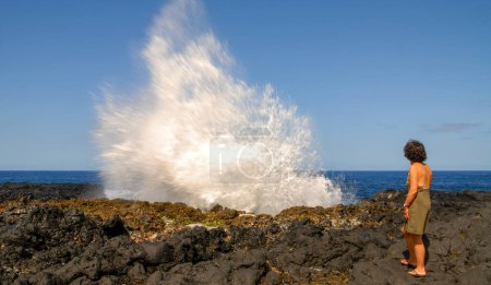 Téléchargez les photos : Une femme près du geyser Le Souffleur à La Réunion près de la ville de Saint Leu - en image libre de droit