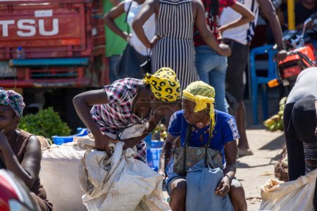 Photo for Pedernales, Dominican Republic, 22 august 2022. Two haitian ladies with yellow bandana hats chatting away while buying and selling. - Royalty Free Image