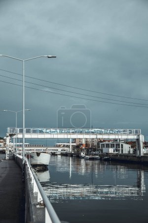 Foto de Bellaria Igea Marina, Italia, 20 feb 2024. Vista del nombre de la ciudad escrito en un puente del canal. Mar de invierno, fuera de temporada, tormenta, cielo dramático, contrastes de color. - Imagen libre de derechos