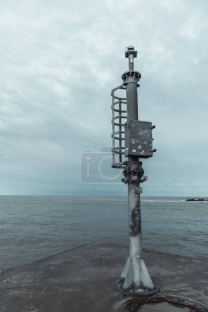 Port and pier equipment, little beacon on the pier in a Riviera Romagnola beach location. dramatic sky in a winter afternoon. Winter sea. Moody and gloomy day.