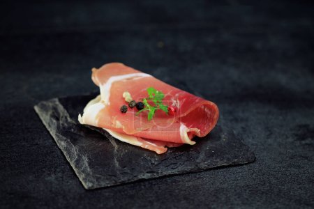 raw ham on black background