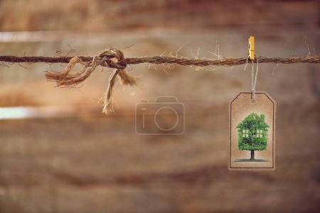 Téléchargez les photos : Immobilier, vente et écologie, corde à linge sur fond bois - en image libre de droit
