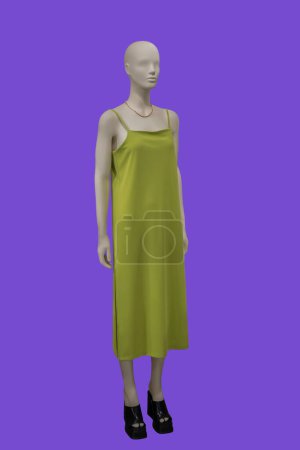 Foto de Imagen de longitud completa de un maniquí de exhibición femenina con vestido de verano verde de moda con tirantes aislados sobre fondo azul - Imagen libre de derechos