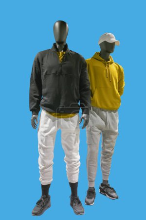 Téléchargez les photos : Two full length images of a male display mannequins wearing fashionable clothes isolated on blue background - en image libre de droit