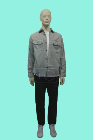 Téléchargez les photos : Image pleine longueur d'un mannequin masculin portant une veste sans boutonnage grise et un pantalon noir isolé sur fond bleu - en image libre de droit