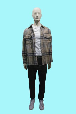 Téléchargez les photos : Image pleine longueur d'un mannequin masculin portant une veste à carreaux brun clair déboutonnée et un pantalon noir isolé sur fond bleu - en image libre de droit