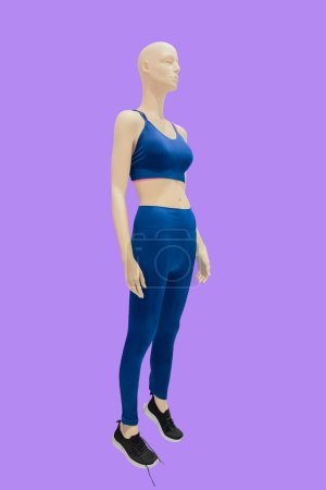 Full length image of a female display mannequin wearing sportswear isolated on a pink background.