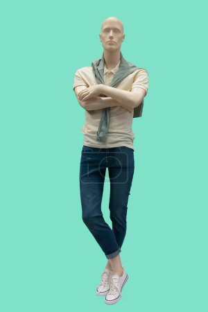 Full length image of a male display mannequin wearing summer casual clothes isolated on green background