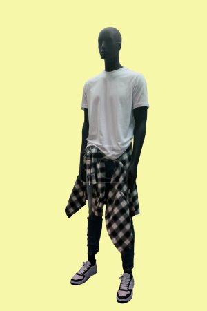 Full length image of a male display mannequin wearing white t-shirt and blue jeans isolated on yellow background