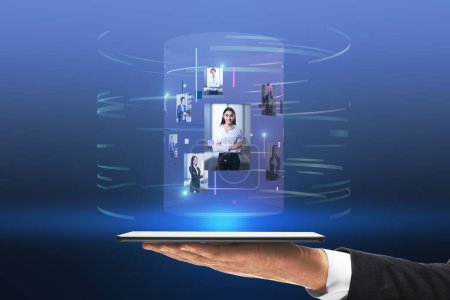 Téléchargez les photos : Gros plan de l'homme d'affaires main tenant tablette avec hologramme image numérique abstraite cylindre sur fond bleu. Informatique, technologie, innovation et médias - en image libre de droit