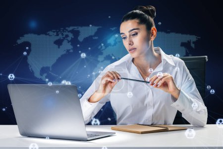 Attraktive junge europäische Geschäftsfrau sitzt am Schreibtisch mit Laptop und abstrakter, leuchtender digitaler Landkarte und Verbindungen auf blauem Hintergrund. Kommunikations- und Netzwerkkonzept