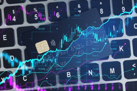 Close up of laptop keyboard with bank card and creative glowing candlestick forex chart on blurry background. Financial trade and market concept. Double exposure