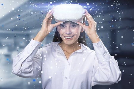 Happy young european businesswoman with abstract hologram and VR glasses in blurry office interior. Augmented reality and cyberspace concept