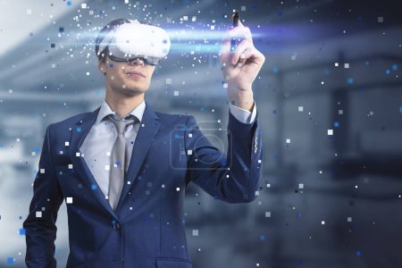 Attractive young european businessman pointing at abstract hologram with VR glasses in blurry office interior. Augmented reality and cyberspace concept