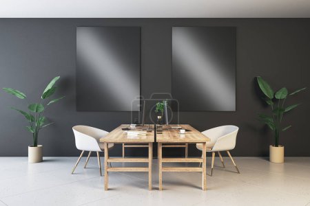 Modern coworking interior with empty black mock up screen on dark wall, desk, computer, chairs, decorative items, plants and supplies. Mock up, 3D Rendering