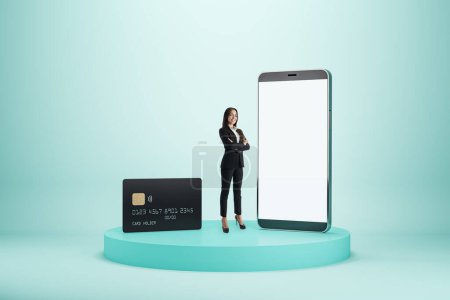 Mobiles Bank- und Online-Bezahlkonzept mit erfolgreicher Frau neben modernem Smartphone mit weißem Bildschirm mit Platz für Ihre Anwendung und schwarzer Kreditkarte auf hellem Hintergrund, Mockup