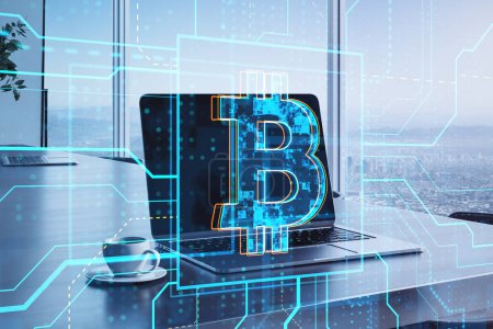 Close up of laptop with glowing circuit bitcoin hologram, coffee cup and notepad on blurry window with city view background. Cryptocurrency and finance concept. Double exposure