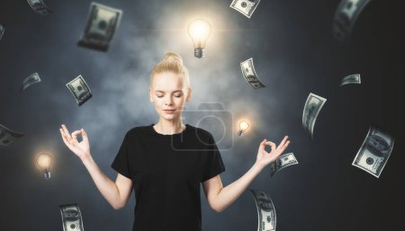 Easy money and thinking idea concept with young woman with eyes closed doing meditation gesture with fingers on foggy background with lighting lightbulbs and dollar banknotes