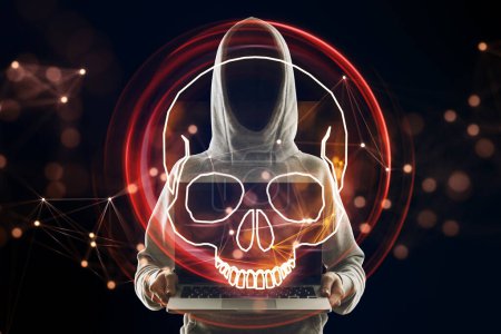 Hacker using laptop with digital red skull hologram on dark background. Ransomeware, virus and pirate threat concept. Double exposure