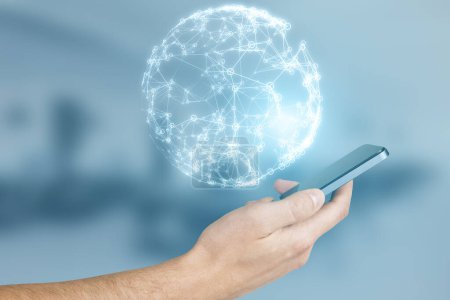 Close up of businessman hand using mobile phone with glowing blue polygonal globe on blurry office interior background. Global technology and metaverse concept