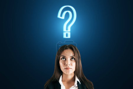 Photo for Thoughtful face of a businesswoman closeup and a sign of question over her head on a dark blue background, doubt and decision concept - Royalty Free Image