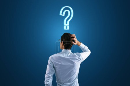 Photo for Back view to a thoughtful businessman and a question mark on his head on a dark blue background, search for a solution and doubt concept - Royalty Free Image