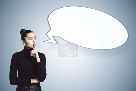 Une femme avec un doigt sur les lèvres et une bulle de parole vide sur un fond bleu clair, représentant le concept de silence