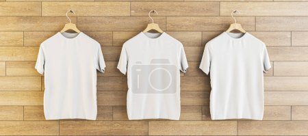 Téléchargez les photos : Three empty white t-shirts hanging on wooden wall background. Ad, textile and fashion concept. 3D Rendering - en image libre de droit