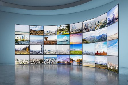 Téléchargez les photos : Plusieurs écrans affichant divers paysages dans une pièce avec sol réfléchissant, murs bleus incurvés et concept de galerie moderne. Rendu 3D - en image libre de droit