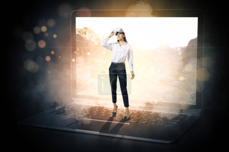 Téléchargez les photos : Image abstraite d'une femme d'affaires heureuse avec des lunettes VR sortant de l'écran flou de l'ordinateur portable bokeh sur fond sombre. Metaverse, ai, concept de réalité virtuelle. - en image libre de droit