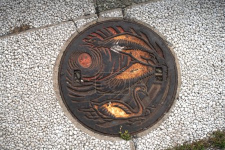 Foto de Nemuro, Hokkaido, Japón - 16 de agosto de 2023 - Escena de tapa de alcantarilla grabada con el símbolo y atractivo de Nemuro - Imagen libre de derechos