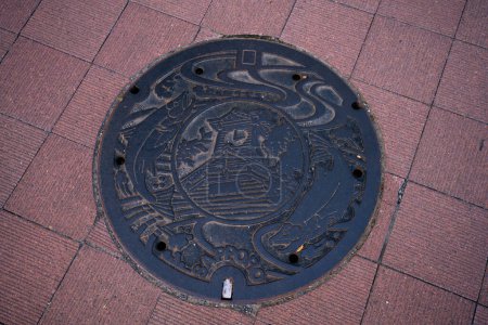 Foto de Sapporo, subprefectura de Ishikari, Hokkaido, Japón - 21 de agosto de 2023 - Escena de tapa de alcantarilla grabada con la Torre del Reloj como símbolo y atractivo de Sapporo - Imagen libre de derechos