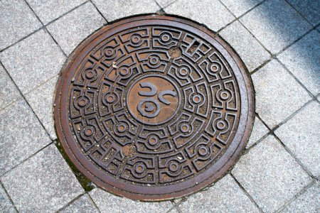 Foto de Otaru, subprefectura de Shiribeshi, Hokkaido, Japón - 22 de agosto de 2023 - Escena de tapa de alcantarilla grabada con el símbolo de Otaru - Imagen libre de derechos