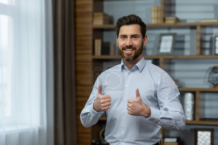 Téléchargez les photos : Successful businessman smiling and looking at camera, man shows thumbs up affirmatively and joyfully agrees with achievement, boss in shirt inside office at work. - en image libre de droit