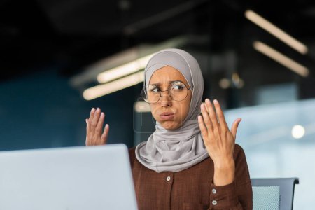 Photo for Heat and heat in the office, business woman in hijab waving her hands trying to refresh and cool down, broken air conditioner at workplace. - Royalty Free Image