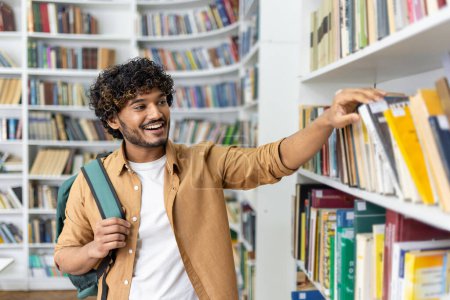 Photo for A young, enthusiastic student with a backpack is selecting a book from a library shelf, showcasing the pursuit of knowledge and academic research in a vibrant, diverse educational setting. - Royalty Free Image
