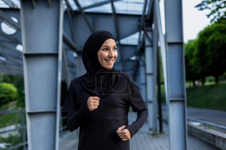 A joyful Muslim woman wearing a hijab enjoys a run in an urban park setting, exuding health and happiness.