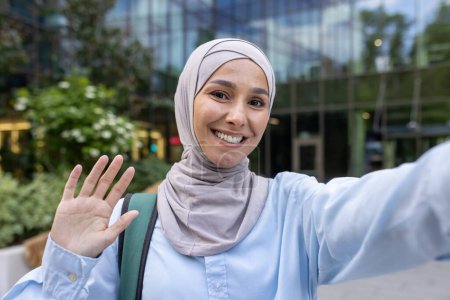 Ein respektvolles Bild, das eine muslimische Frau im Hidschab zeigt, die ihre Hand hebt, um Fotos in einer städtischen Umgebung abzulehnen, und Privatsphäre und Einwilligung verkörpert.