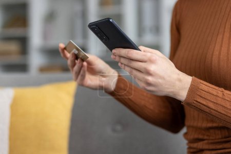 Foto de Mujer usando smartphone y tarjeta de crédito para compras en línea con enfoque en manos y dispositivos. - Imagen libre de derechos